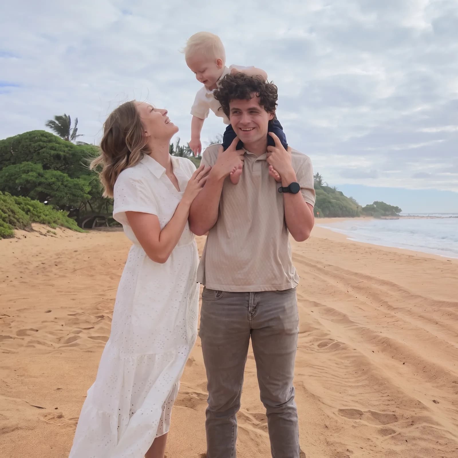 Morgan and Haley Kotter on a beach, Haley laughing up at their baby, Kai, who sits on Morgan's shoulders