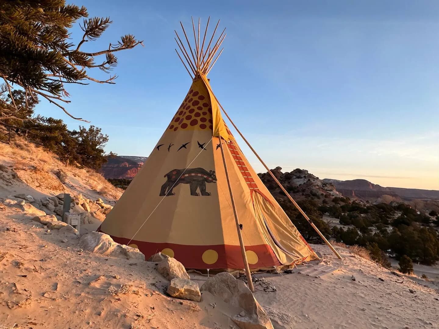 The Bear tipi at sunset with the valley behind