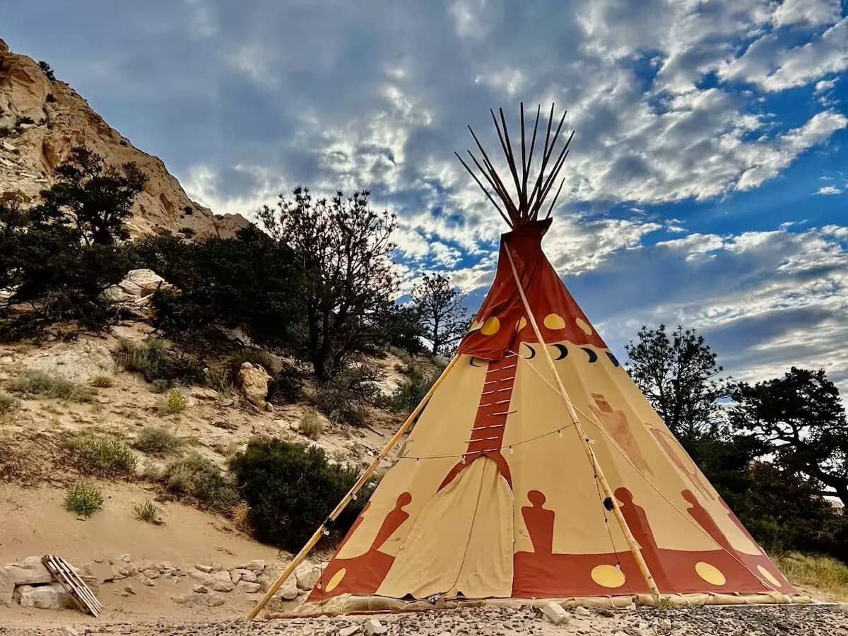 The Bison tipi with its painted bison against a cloudy sky