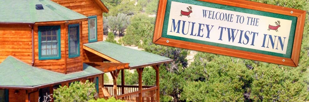 The Muley Twist Inn's welcome sign beside the timber building and its covered deck, from the inn's website header, around 2014
