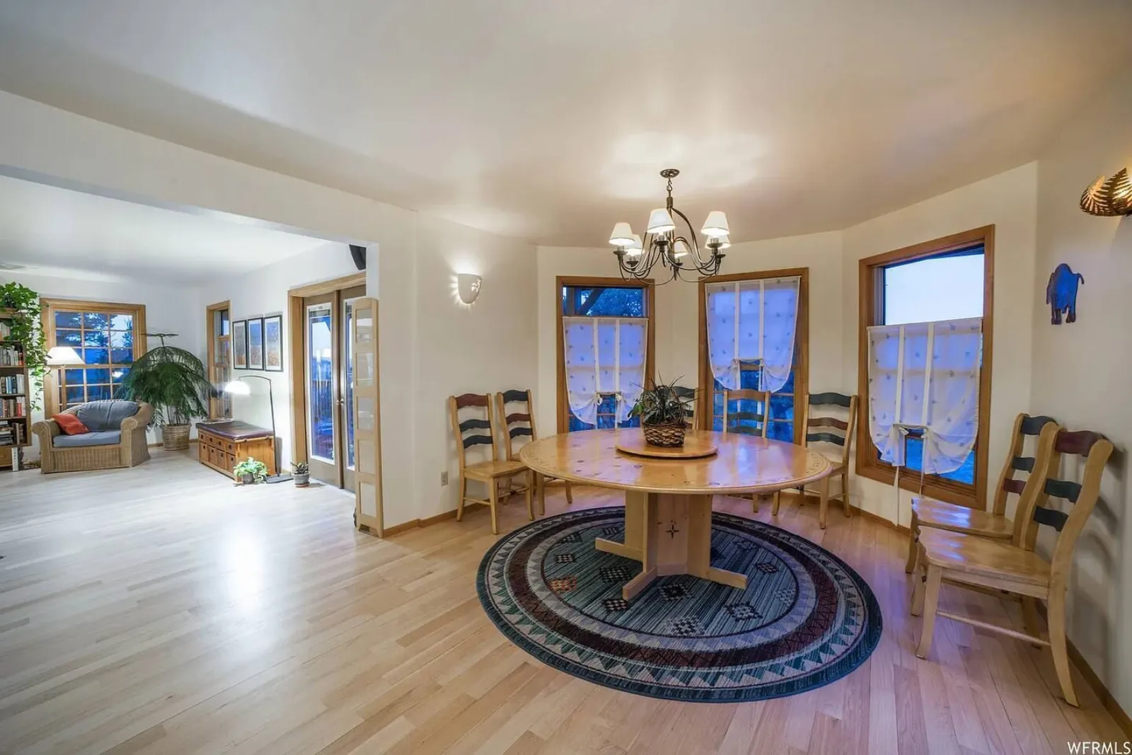 The Lodge's open common room, with a round dining table, wood floors and windows on two sides