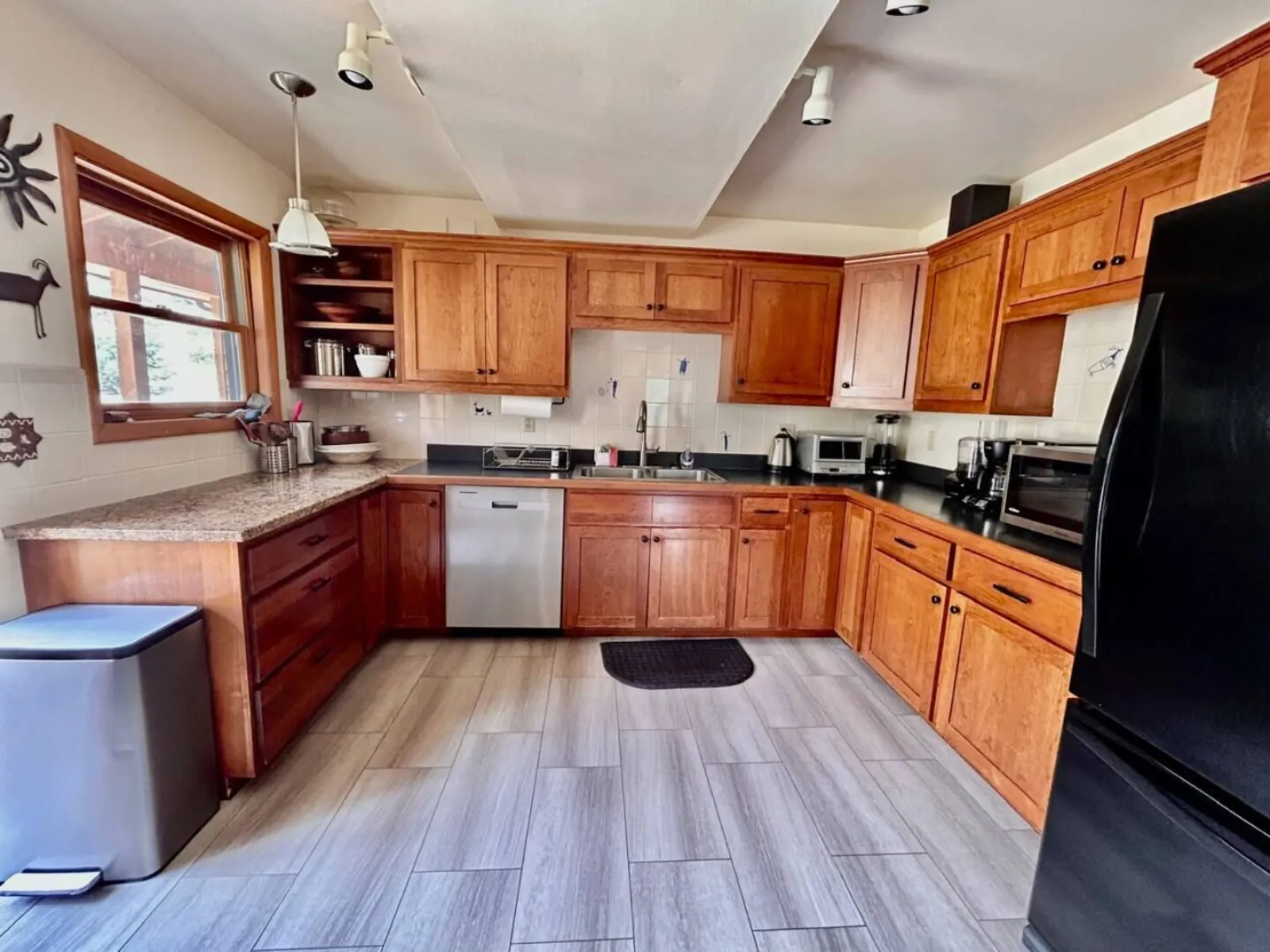 The shared kitchen in The Lodge — full-size cooker, dishwasher, fridge and wood cabinetry