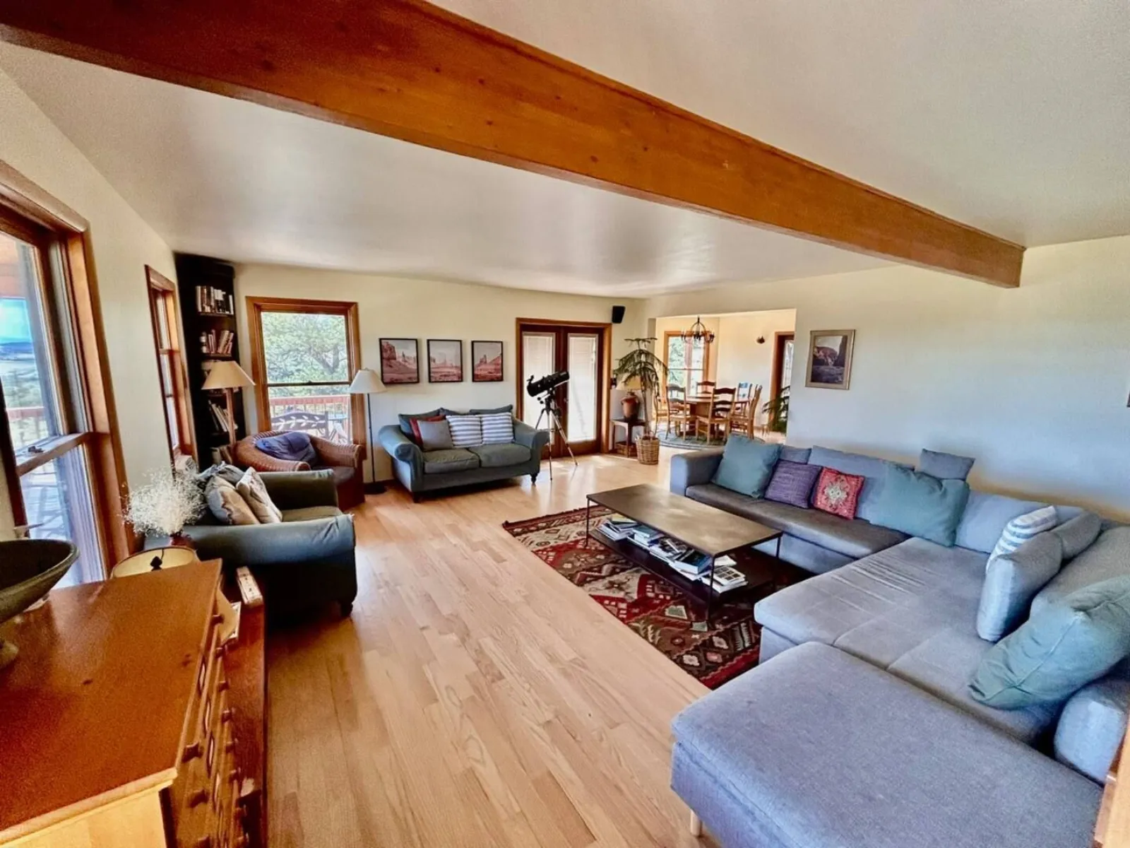 A seating area in The Lodge with sofas, a beamed ceiling and a desk under the window
