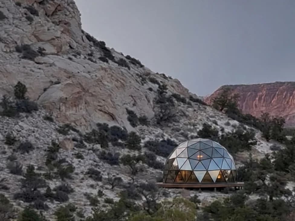 Visualisation of a planned tempered-glass geodesic dome on the property's existing dome site, below white sandstone and red cliffs near Capitol Reef National Park