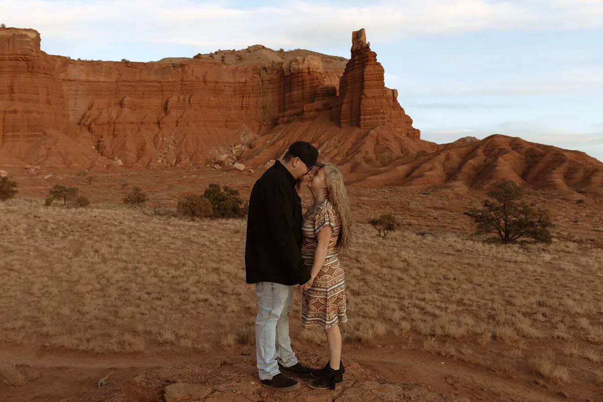 A couple embracing in front of a sandstone butte